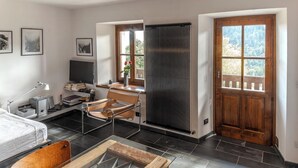A modern room with a bed, desk, chair, and a radiator. - Restored 19th century house with Dolomites view (Sauris di Sopra)