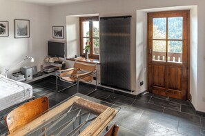 Una habitación moderna con cama, escritorio, silla y radiador.