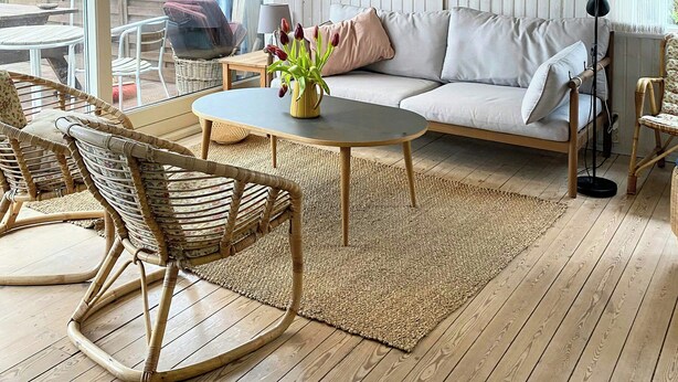 A cozy living room with a sofa, a coffee table, wicker chairs, a rug, and a painting on the wall. - Summer house near beach in Odder (Odder)