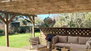 A wooden deck with a picnic table, two chairs, a sofa, and a small table. - Summer house near beach in Odder (Odder)