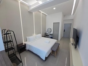 A modern hotel room with a large bed, bedside table, a desk with a chair, a mirror, a bench, and a TV mounted on the wall. - One Point Hotel TT3 Tabuan Tranquility (Kuching)