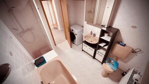 Ein Badezimmer mit Badewanne, Toilette, Waschbecken und Dusche.