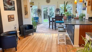 A spacious kitchen with a dining area, wooden flooring, and various potted plants. - Perfect Basecamp to explore the PNW and FIFA World Cup, easy walk to lightrail (Shoreline)