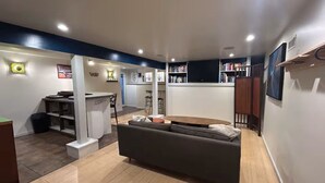 A modern living room with a sofa, a dining area, and a kitchen in the background. - Perfect Basecamp to explore the PNW and FIFA World Cup, easy walk to lightrail (Shoreline)