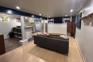 Ein modernes Wohnzimmer mit einer Couch, einem Essbereich und einer Küche im Hintergrund.
