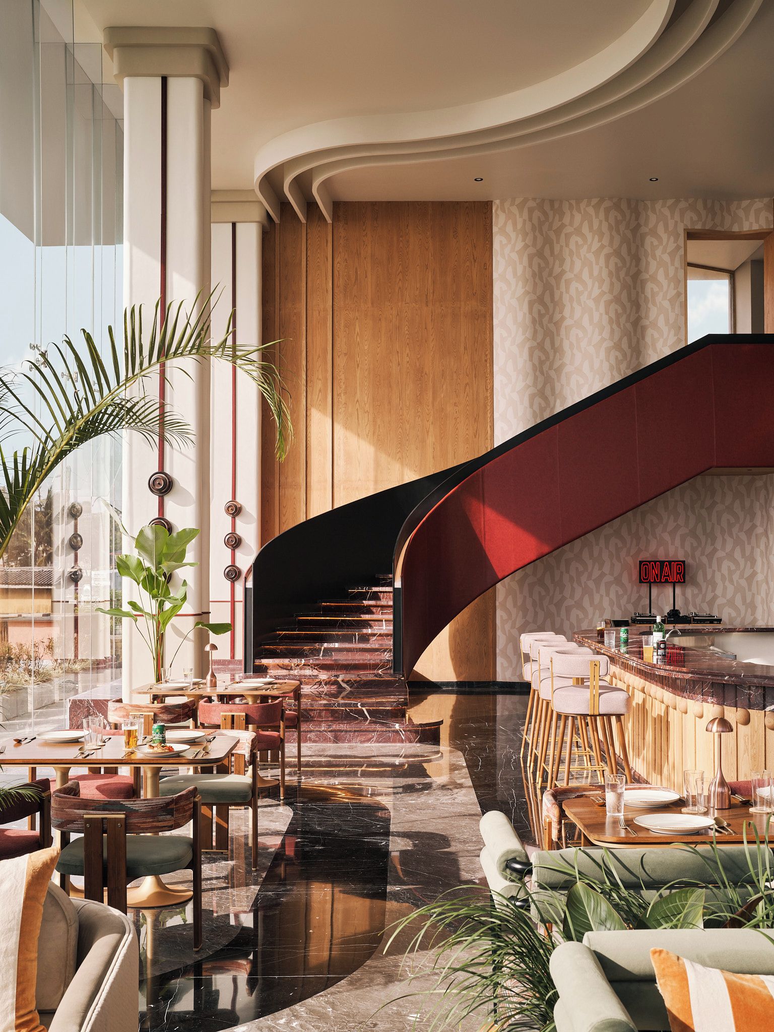 A modern interior with a curved staircase, a bar area, and seating arrangements.