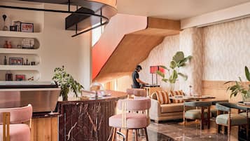 A modern interior with a curved bar, seating area, and a staircase.