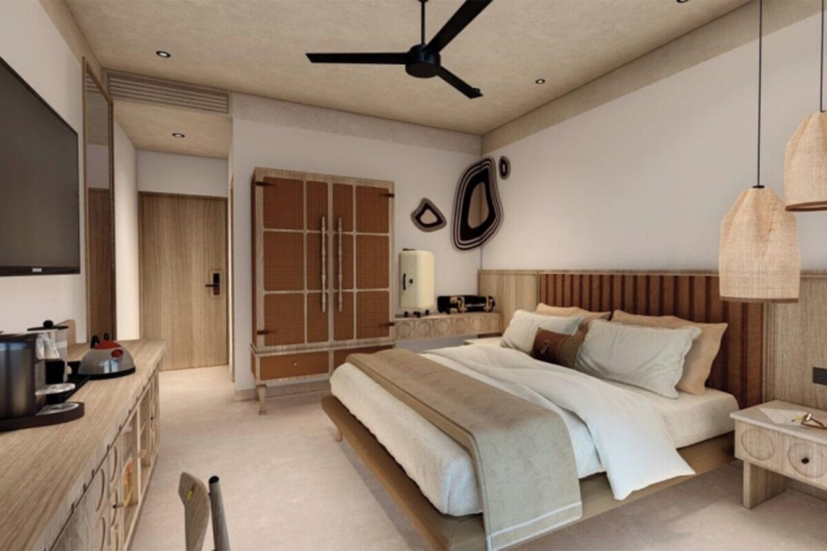 Une chambre moderne avec un lit, des tables de chevet, un ventilateur de plafond et un téléviseur.