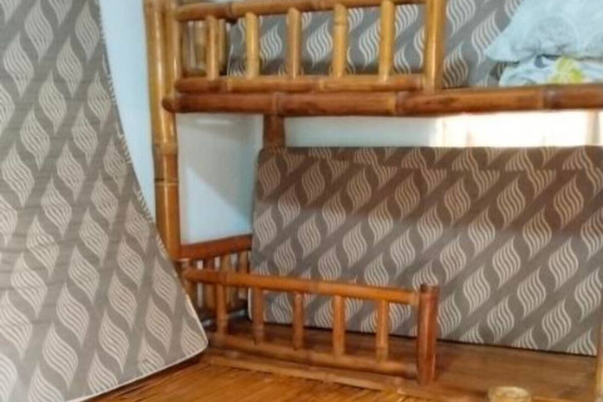 Un lit superposé avec une structure en bois et une literie à motifs.
