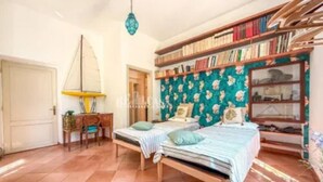 A bedroom with two beds, a bookshelf, a desk, and a hanging lamp. - mare in pineta (San Benedetto del Tronto)
