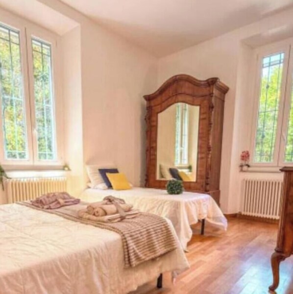 A room with two beds, a large mirror, and large windows. - mare in pineta (San Benedetto del Tronto)