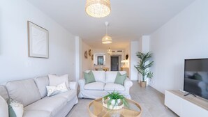 Ein modernes Wohnzimmer mit einer Couch, einem Couchtisch und einem Fernseher.
