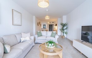 Ein modernes Wohnzimmer mit einer Couch, einem Couchtisch und einem Fernseher.
