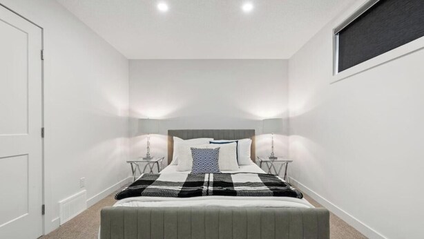 A bedroom with a bed, bedside tables, and a window. - Orchards Delight | Near Airport | Sleeps 4 | WiFi (Edmonton)