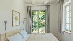 A bedroom with a bed, a window, and a view of an outdoor area. - Tower villa apartment with pergola at Mühlenberg (Werder (Havel))