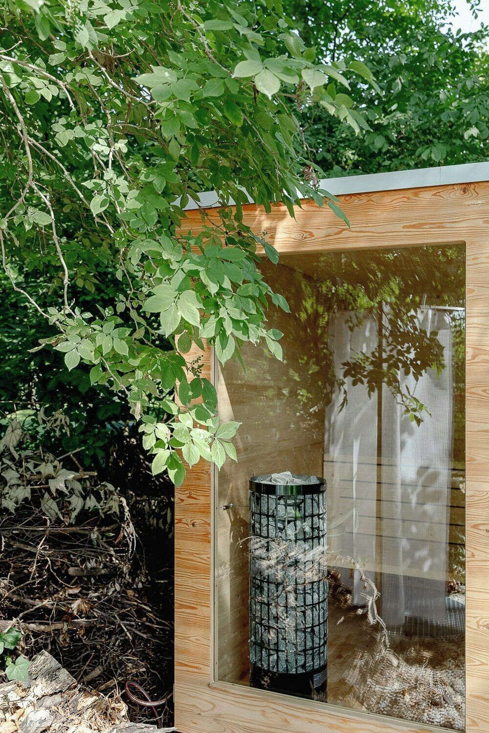 A wooden structure with a glass enclosure, a cylindrical object inside, and a nest outside.