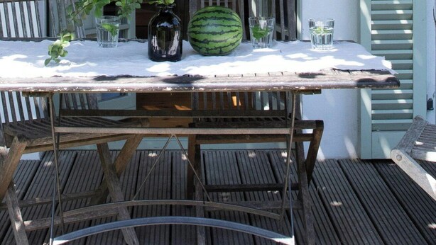 An outdoor dining area with a table, chairs, and a watermelon centerpiece. - Tower villa apartment with pergola at Mühlenberg (Werder (Havel))