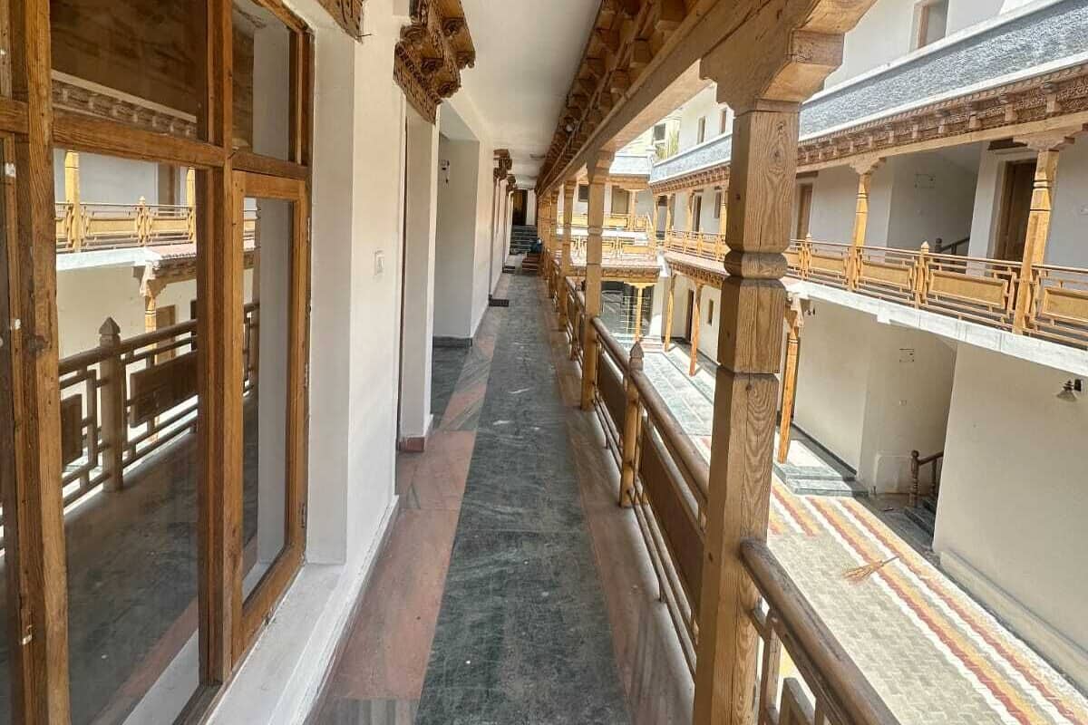 A corridor with wooden railings and large windows.