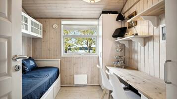 A compact room with a bed, a desk, and a window with a view.