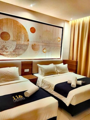 A hotel room with two beds, a large abstract painting on the wall, and a view of the city. - 118 Grand Hotel (George Town)