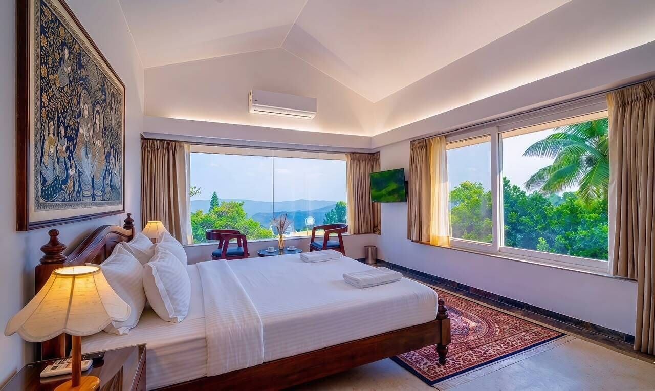 Habitación de hotel con una cama grande, un televisor, un cuadro y vistas al exterior.