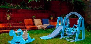 A children's play area with a slide, swing set, and rocking horse. - Table Land Retreat (Mahabaleshwar)