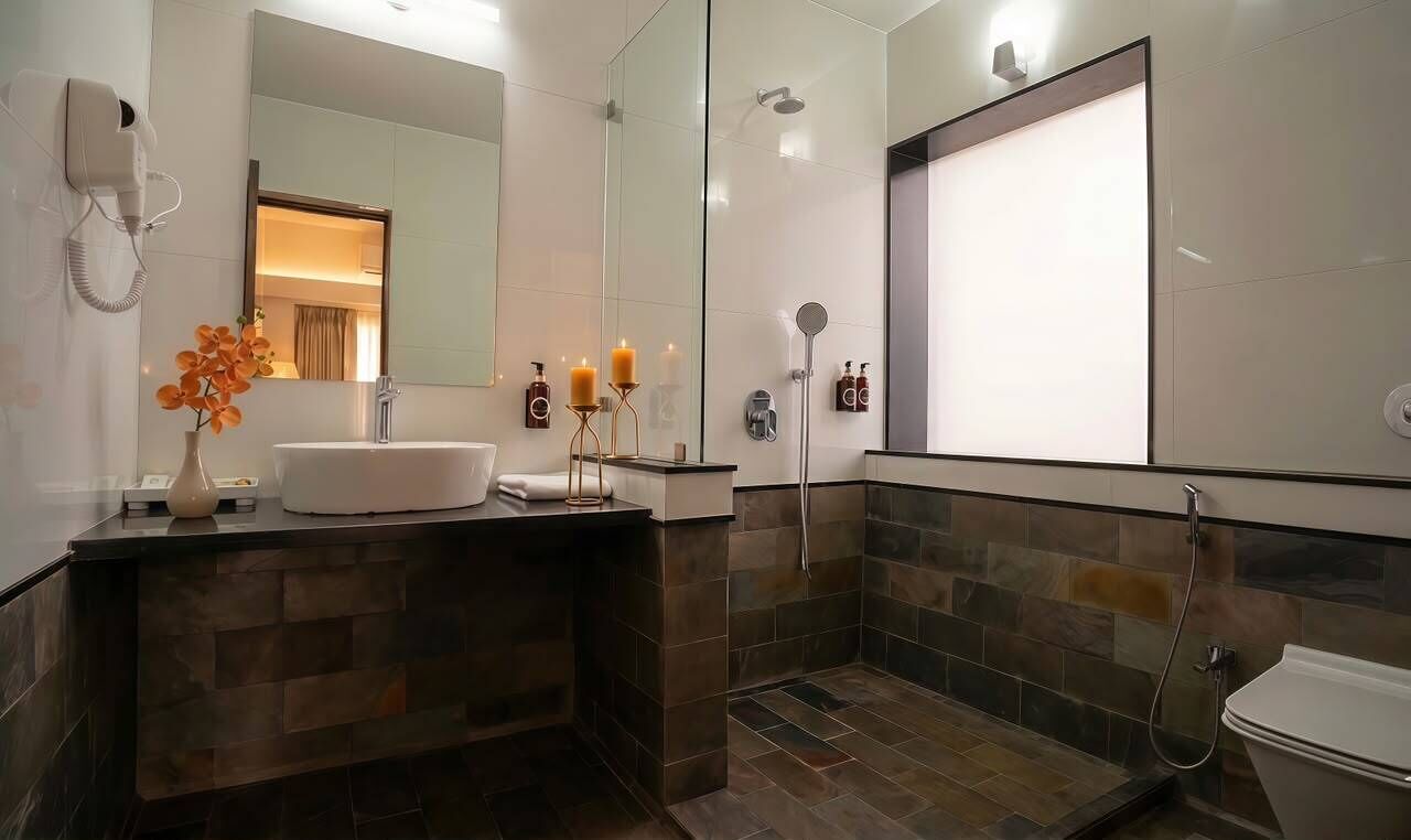 A modern bathroom with a large mirror, a sink, a shower, and a toilet.