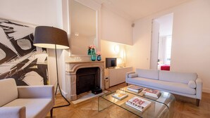 A living room with a fireplace, a sofa, a coffee table, and a lamp. - MARAIS, LIVELY, 3BR, REFURB., LIFT, 30–60 days ahead? Private offer FLO-VBp (Paris)
