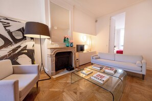 Ein Wohnzimmer mit Kamin, einer Couch, einem Couchtisch und einer Lampe.
