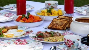 A table set with breakfast items including toast, eggs, and fruit. - KING PALACE BY VOYE HOMES (Ooty)