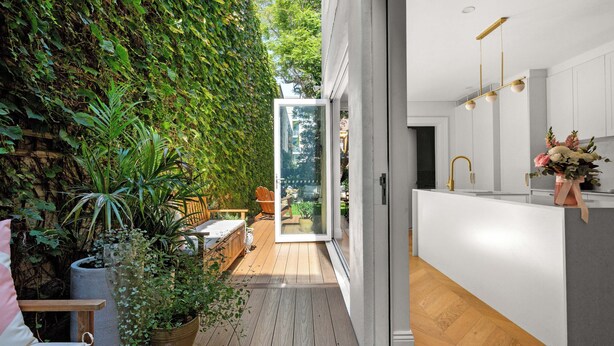 A modern kitchen with white cabinets, a wooden countertop, and a built-in oven. - Chic Inner-City Oasis in the Heart of Sydney (Redfern)