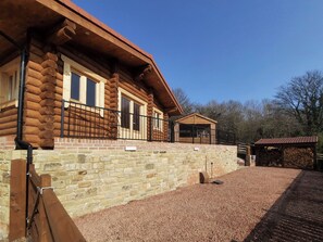 A log cabin with a stone foundation, a balcony, and a small attached structure. - 1 bedroom accommodation in Ebchester, near Consett (Ebchester, near Consett)