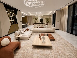 Un salon moderne avec un canapé, une table basse et un lustre.