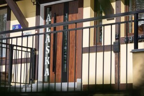 A hotel entrance with a metal gate and a wooden door.
