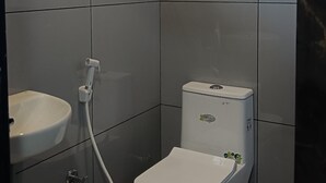 Un baño con inodoro, lavamanos y ducha.