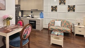 A modern living room with a dining area, a kitchen in the background, and a large water dispenser.