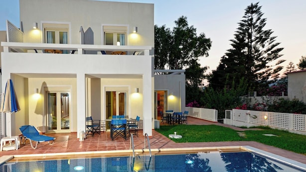 A two-story building with a swimming pool, outdoor seating, and a well-maintained garden. - Oliv Apartments (Rethymno)