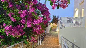 A pathway leading to a building with a white fence and a balcony. - Oliv Apartments (Rethymno)