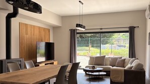 Un salon moderne avec une table à manger en bois, un canapé et un téléviseur.