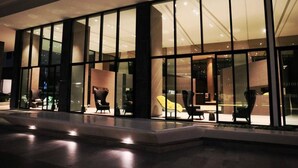 A modern building with large glass windows and a well-lit interior. - 2 Bed Room Sea View Luxury - Best Location in Pattaya (Muang Pattaya)
