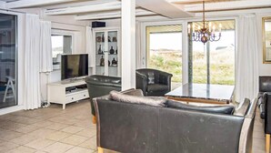 Una sala de estar moderna con un sofá, televisor y una vitrina.