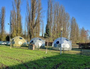 Tre strutture a cupola geodetica in un parco.