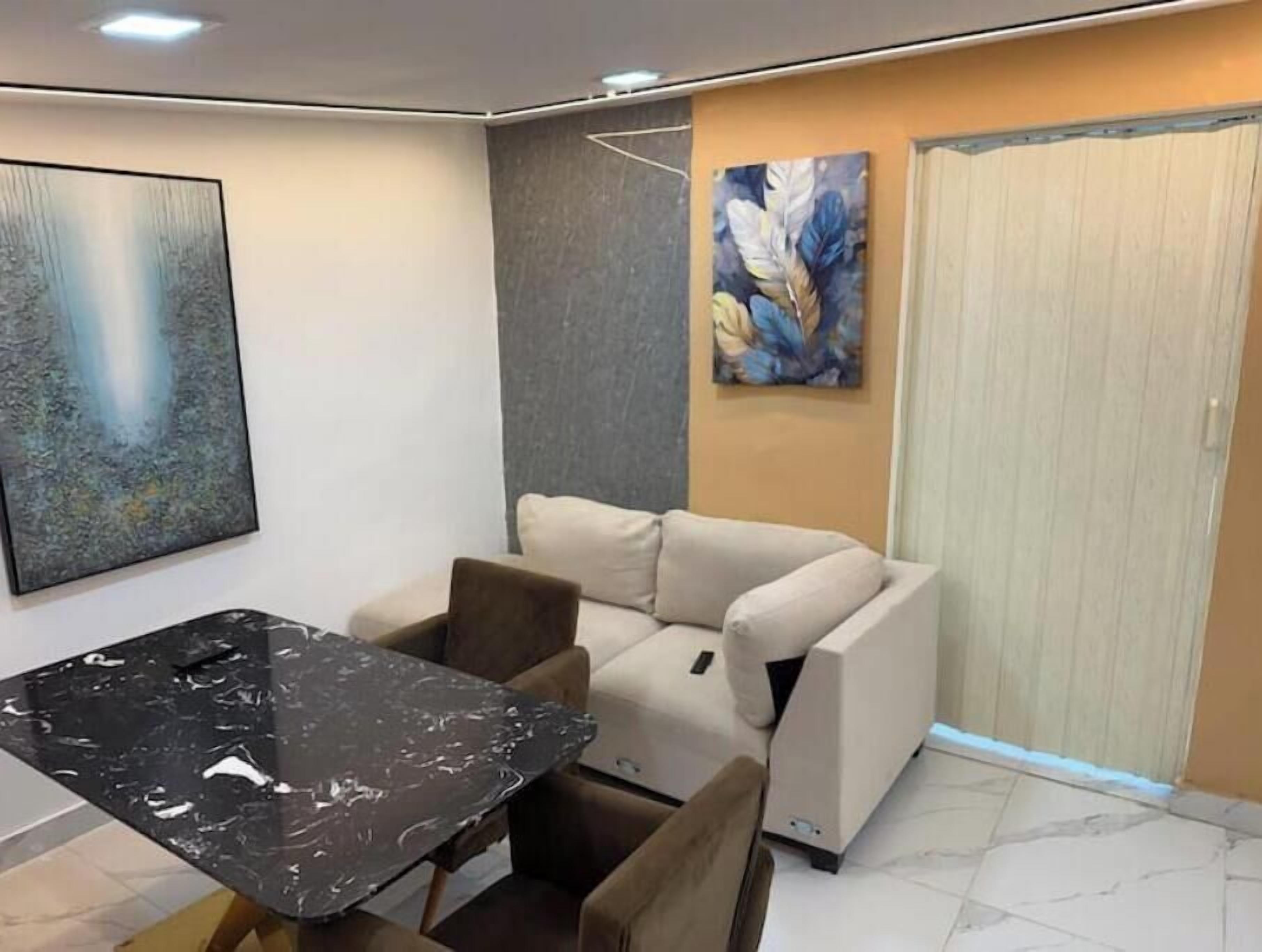 Quarto moderno com sofá, mesa de jantar e um quadro na parede.