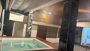 Ein modernes Badezimmer mit einer Glaskabinentoilette, Holzvertäfelung und einer Marmorsäule.