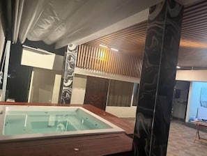 Ein modernes Badezimmer mit einer Glaskabinentoilette, Holzvertäfelung und einer Marmorsäule.