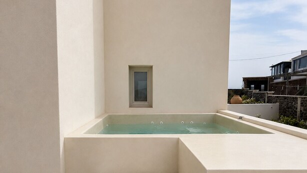 A spa area with a hot tub, steps, and a towel. - Vespera Private Luxury Suites (Santorini)