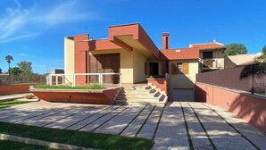 Una casa moderna con tetto piatto, un piccolo portico e un vialetto lastricato.