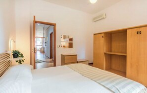A bedroom with a bed, wooden wardrobe, bedside tables, a potted plant, and a hallway leading to another room. - Villa in Comiso with 3 bedrooms sleeps 6 (Comiso)