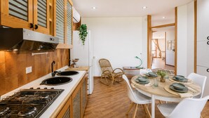 Una cucina moderna con piano cottura a gas, mobili in legno e zona pranzo con tavolo rotondo e sedie.