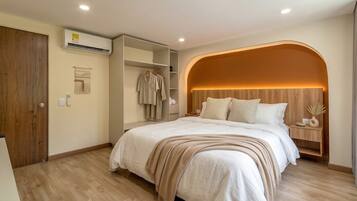 Quarto com cama, guarda-roupa, mesa de cabeceira e design de parede em arco.